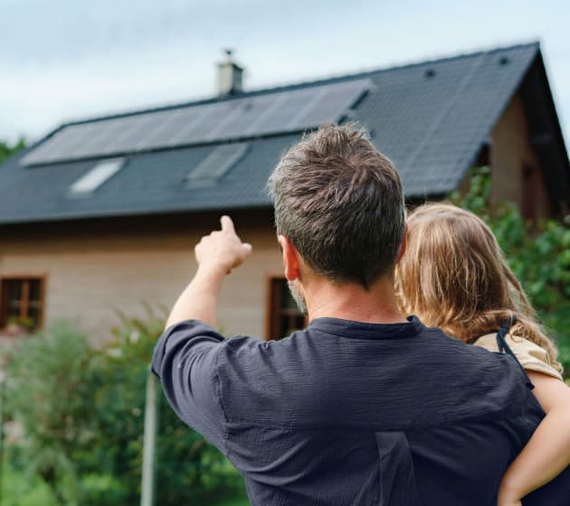 Customer pointing at solar panels on their homes rooftop